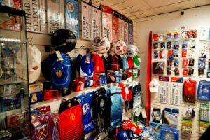 In Off The Far Post retail display showing club scarves, hats and footballs