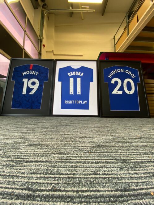 3 football shirts framed up and on display at the TSFS HQ. These shirts are all Chlesea FC shirts. Mount, Drogba and Hudson Odoi